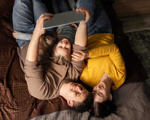 Familia de tiro medio tendido en la cama