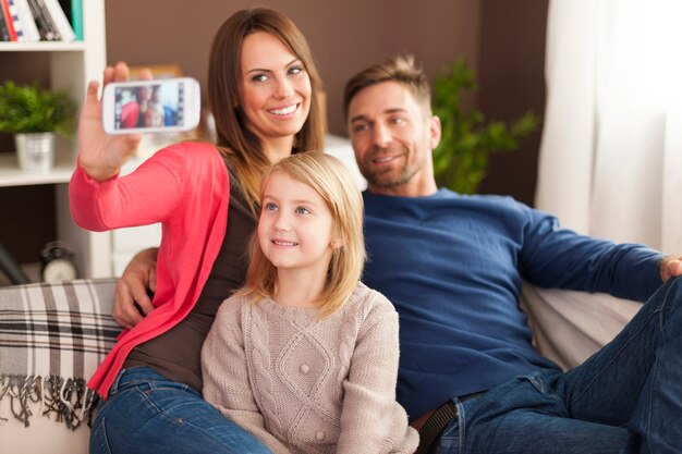 Familia tomando fotografías de autorretrato por teléfono móvil