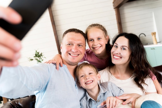 Foto gratuita familia tomando selfie en casa