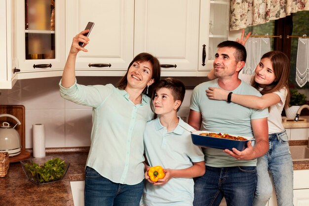 Familia tomando selfie en la cocina antes de la cena