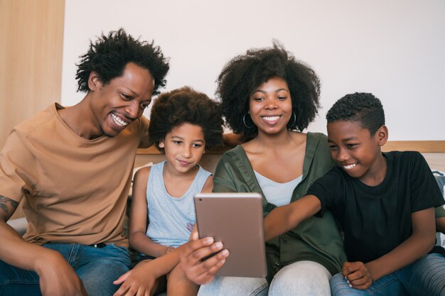 Familia tomando selfie junto con tableta en casa.