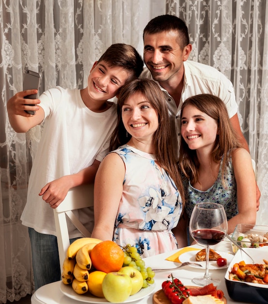 Familia tomando selfie juntos mientras cenan