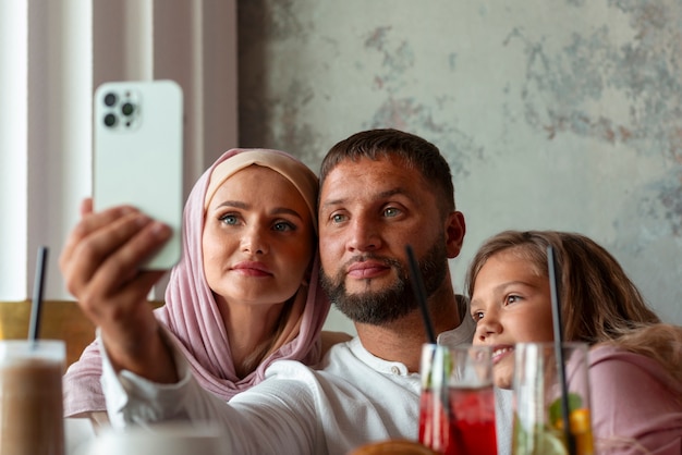 Familia tomando selfie juntos mientras están en un restaurante