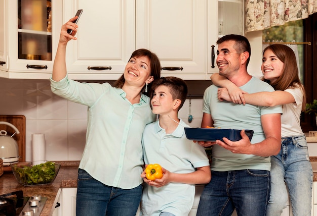 Familia tomando selfie juntos mientras prepara la cena