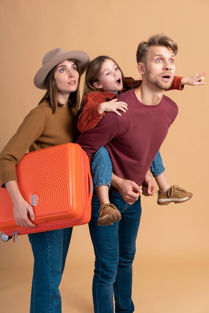 Familia de tres listos para unas vacaciones de viaje junto con el equipaje