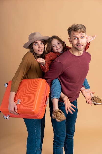 Familia de tres listos para unas vacaciones de viaje junto con el equipaje