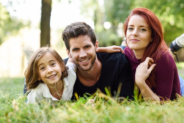 Familia tumbada en el césped de un parque