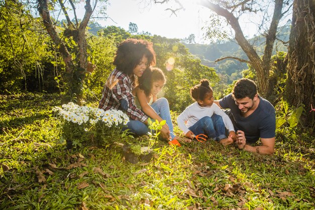 Familia tumbada en colina herbosa