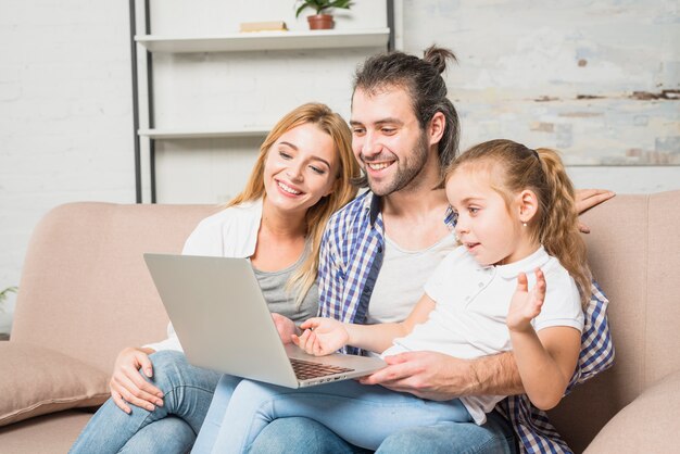 Familia usando el portátil en el sofá