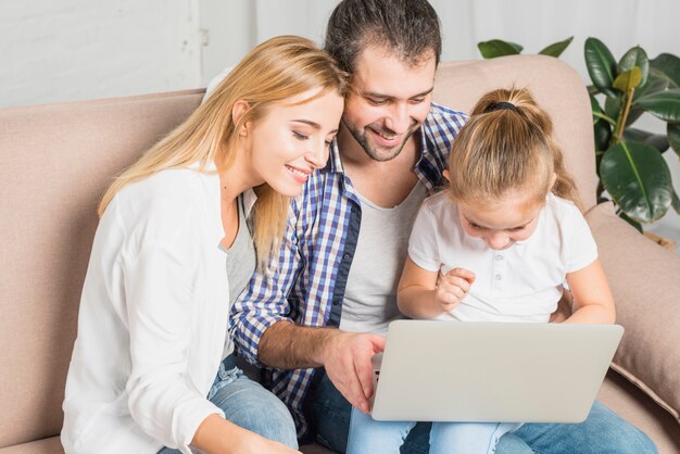 Familia usando el portátil en el sofá