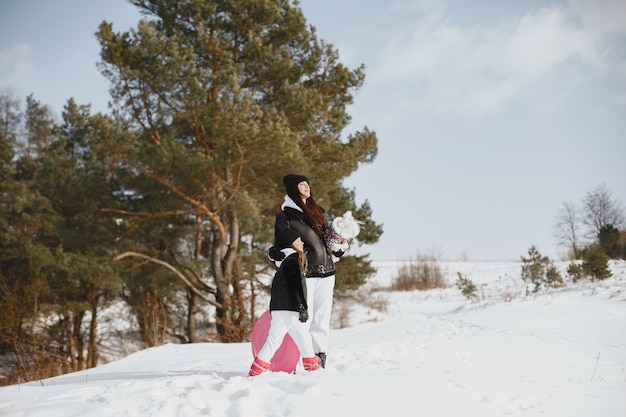 Familia en vacaciones familiares de Navidad. Mujer y niña en un bosque. La gente camina.