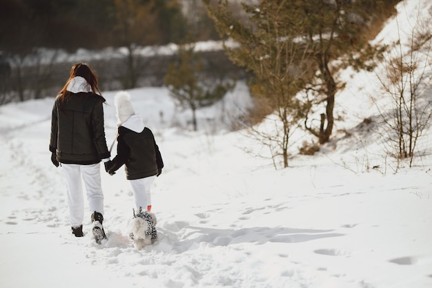 Familia en vacaciones familiares de Navidad. Mujer y niña en un bosque. La gente camina.