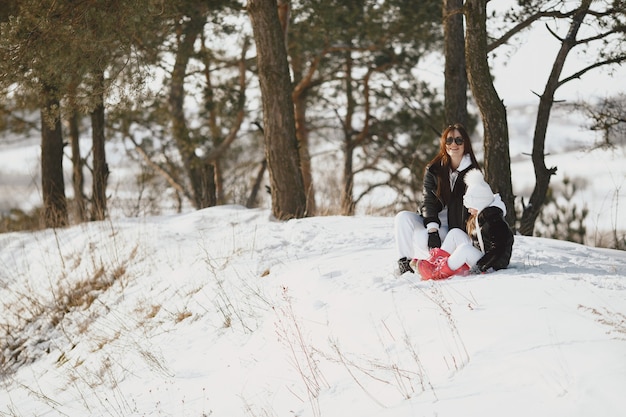 Familia en vacaciones familiares de Navidad. Mujer y niña en un bosque. La gente camina.