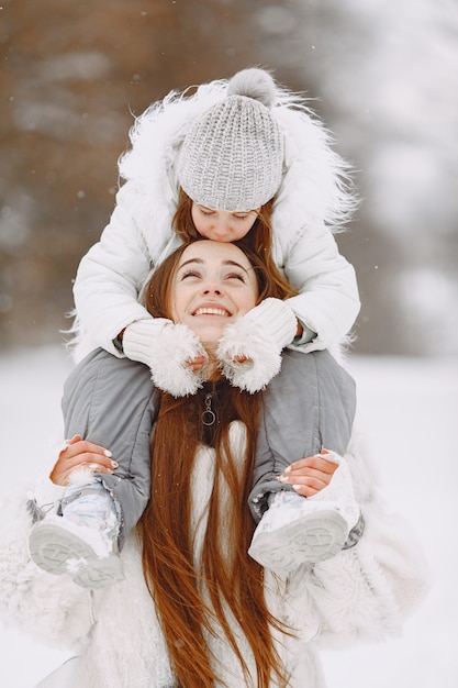 Familia en vacaciones familiares de Navidad. Mujer y niña en un parque. La gente camina.