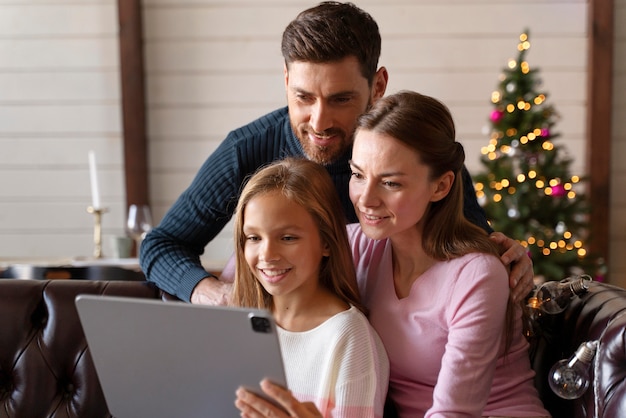 Foto gratuita familia viendo un video en su tableta el día de navidad