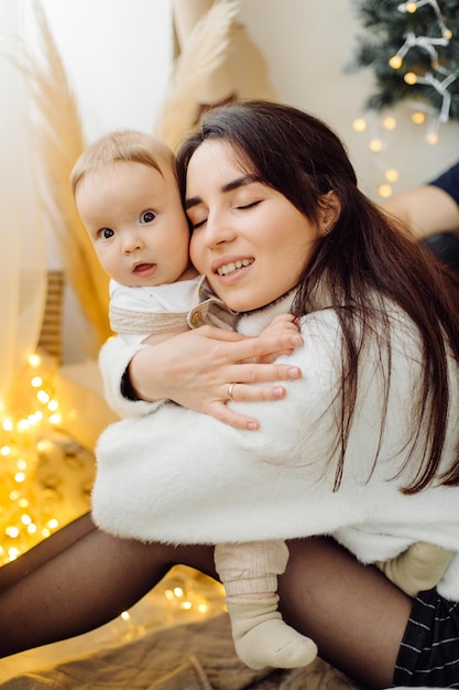 Familias retrato de feliz joven madre y padre con niño posando en el interior del hogar