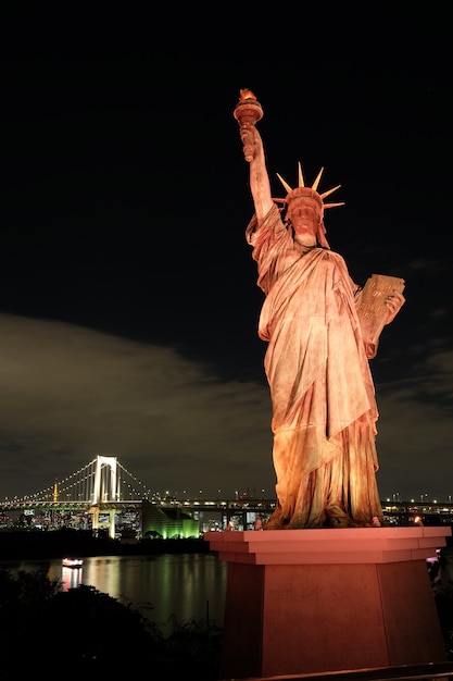 Foto gratuita la famosa estatua histórica de la libertad tocando el cielo nocturno en odaiba, tokio, japón