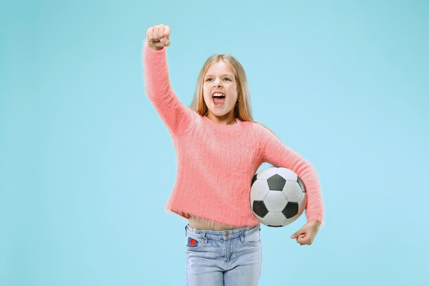 Fan deporte jugador adolescente sosteniendo un balón de fútbol aislado en azul