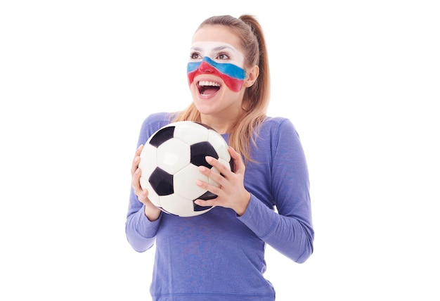 Fan femenino extático con vítores de balón de fútbol