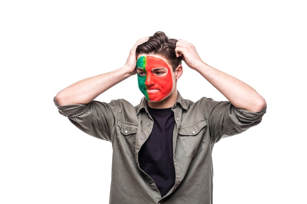 El fanático del partidario del hombre guapo de la cara de la bandera pintada del equipo nacional de Portugal se pone triste, triste, frustrado, emoitions en una cámara. Fans de las emociones.