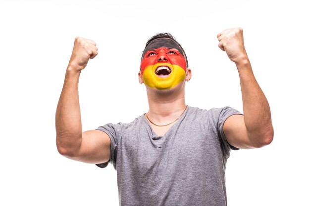 El fanático del partidario del hombre guapo del equipo nacional de Alemania con la cara de la bandera pintada obtiene una victoria feliz gritando en una cámara Fans de las emociones.