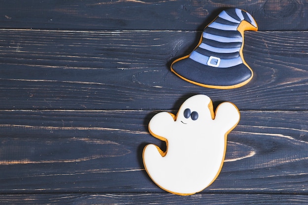 Fantasma de Halloween con galletas de sombrero de bruja en el escritorio