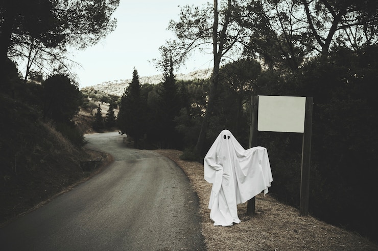 Foto gratuito fantasma sombrío de pie cerca de tablero de la muestra en el bosque
