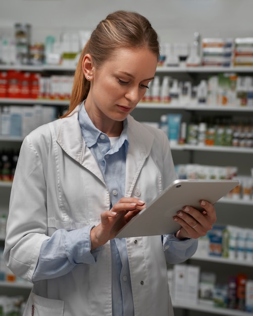 Farmacéutica con mesa comprobando stock en farmacia