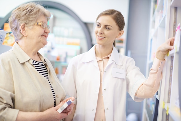 Foto gratuita farmacéutico cuidando la salud de la mujer madura