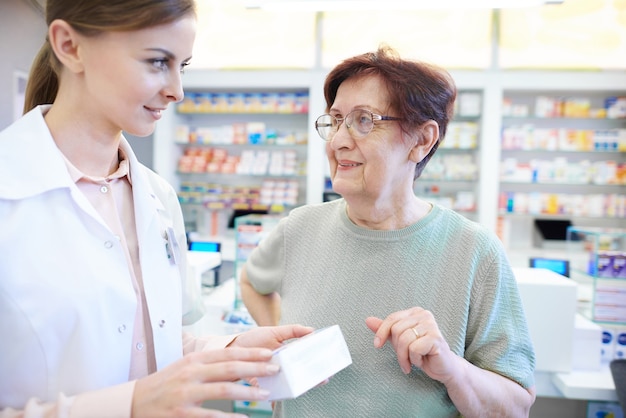 Farmacéutico femenino ayudando a mujer mayor