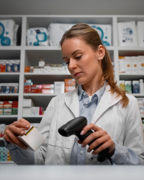 Farmacéutico femenino escaneando medicina en el mostrador