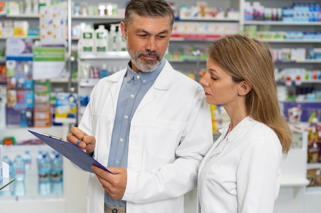 Foto gratuita farmacéuticos de tiro medio en el trabajo.