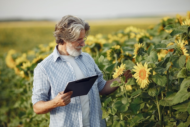 Farmer examina el campo. Agrónomo o agricultor examina el crecimiento del trigo.