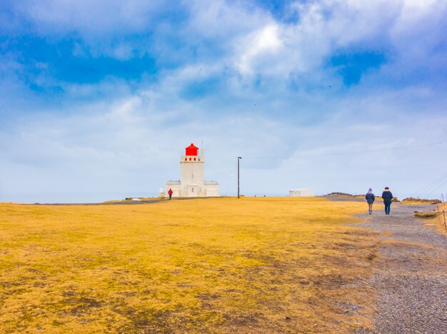 Faro blanco en el cabo Dyrholaey, Islandia. .