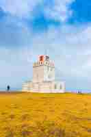 Foto gratuita faro blanco en el cabo dyrholaey, islandia. .