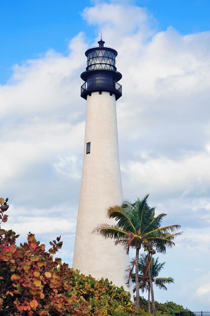 Faro de Cape Florida Light con Océano Atlántico y palmera en la playa de Miami con cielo azul y nubes.