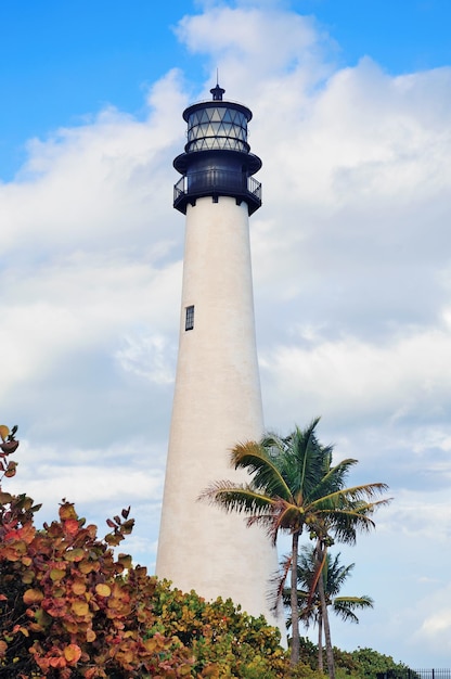 Faro de Cape Florida Light con Océano Atlántico y palmera en la playa de Miami con cielo azul y nubes.