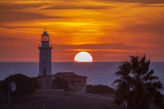 Foto gratuita faro de hormigón blanco durante la puesta de sol