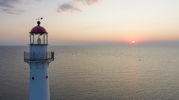 Foto gratuita faro de la isla de kihnu en estonia durante una hermosa puesta de sol