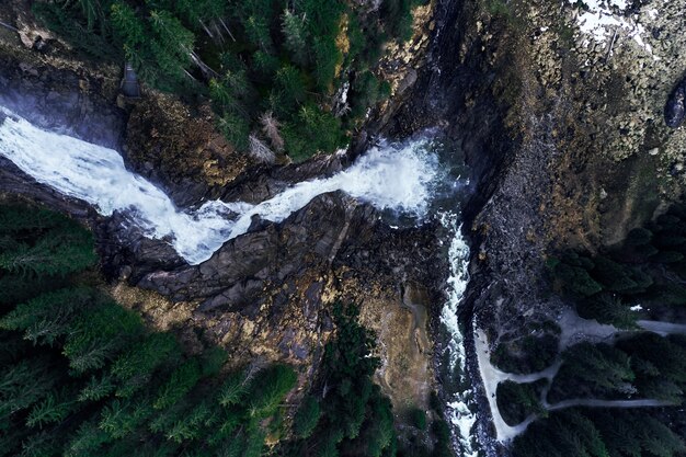 Fascinante disparo de alto ángulo del origen de una cascada sobre rocas en un bosque