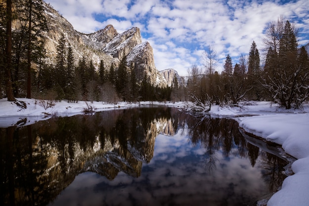 Fascinante paisaje de un reflejo de montañas rocosas nevadas en el lago