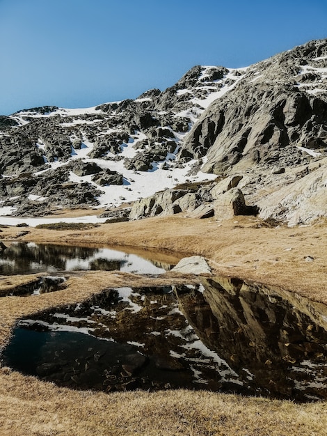 Fascinante vista del agua que refleja los alrededores en la montaña Penalara en España