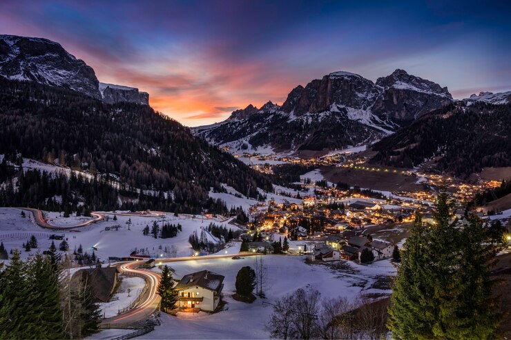 Foto gratuito fascinante vista de las casas en los campos cubiertos de nieve rodeados de montañas y árboles