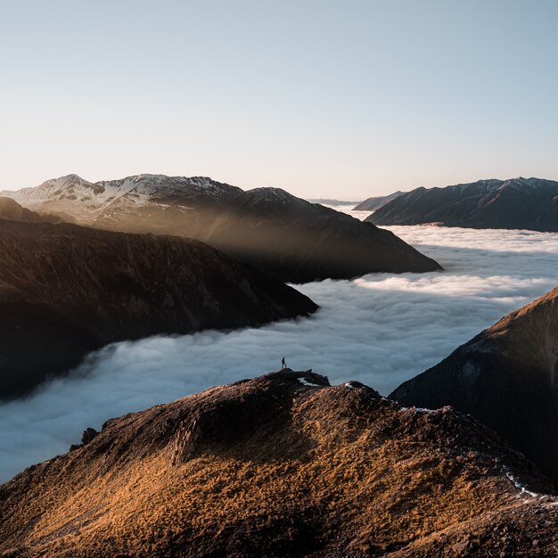 Fascinante vista de un hermoso paisaje montañoso con niebla cremosa otoñal