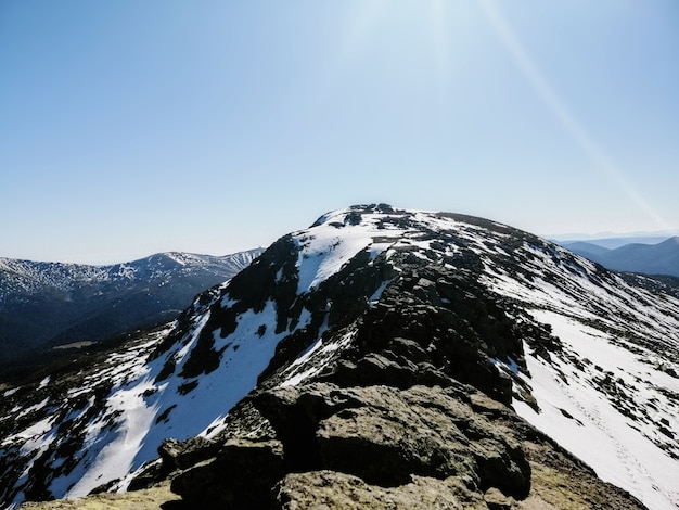 Fascinante vista de la montaña Penalara en España cubierto de nieve en un día soleado