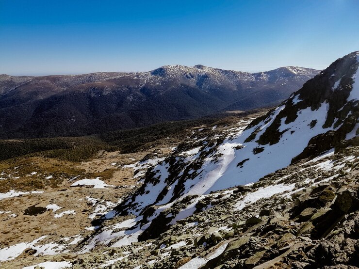 Foto gratuito fascinante vista de la montaña penalara en españa cubierto de nieve en un día soleado