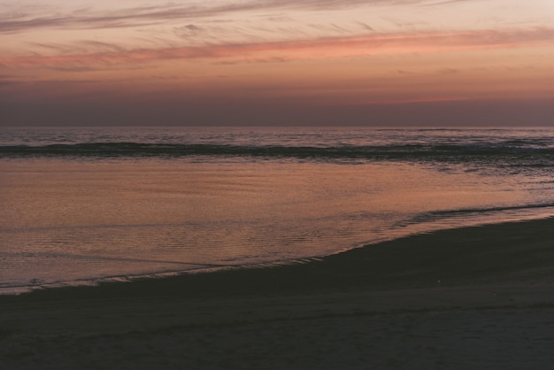 Fascinante vista del océano y la playa durante la puesta de sol