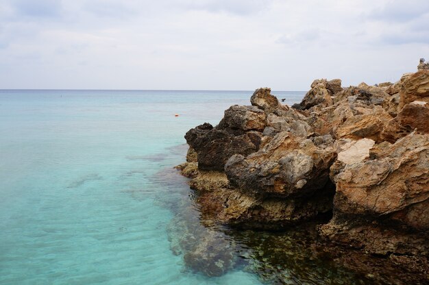 Fascinante vista del océano y las rocas en la playa bajo el cielo azul