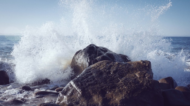 Fascinante vista de las olas del océano chocando contra las rocas cerca de la orilla