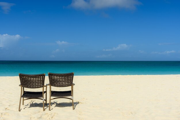 fascinante vista de la playa y el mar, con dos sillas en la orilla